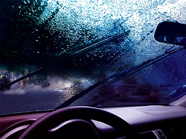 Rain covered windshield viewed from the driver's seat