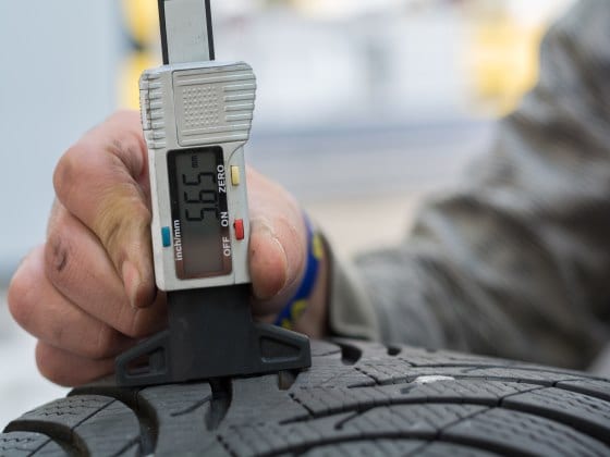 Technician Checking Tires For Tread Depth